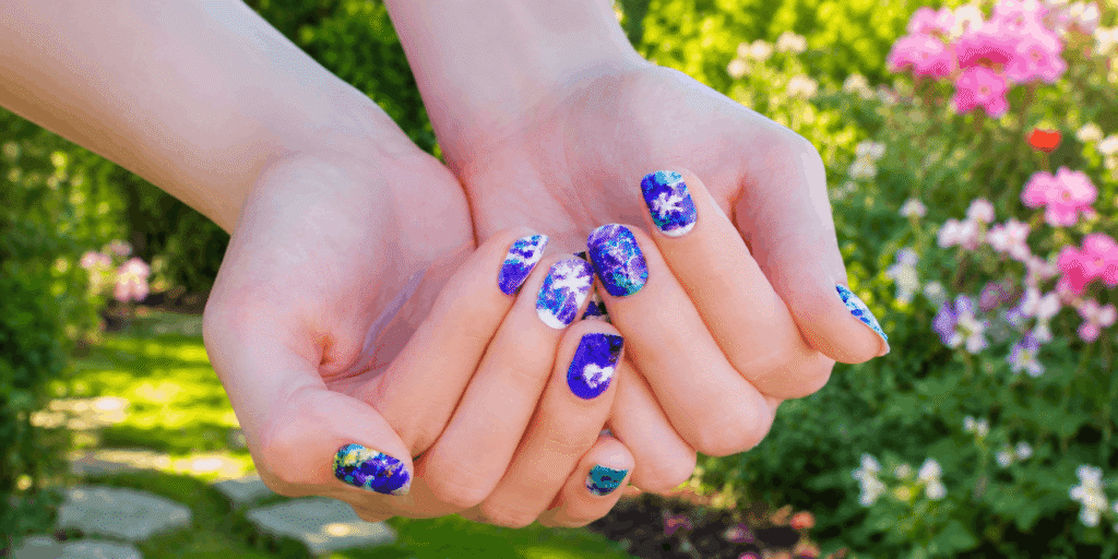 Purple and blue glitter nail designs on manicured hands