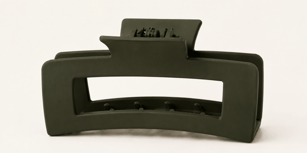 Dark green rectangular hair claw clip on a light neutral background